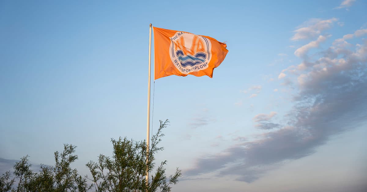 De NWD-vlag wappert boven een NWD-erkende vaarlocatie — symbool voor officiële erkenning door het Watersportverbond.